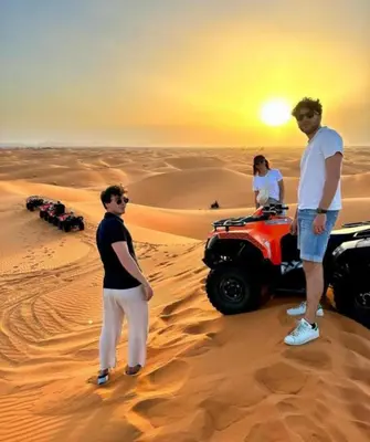 a group of people standing in the desert at Riad Berber Merzouga in Merzouga