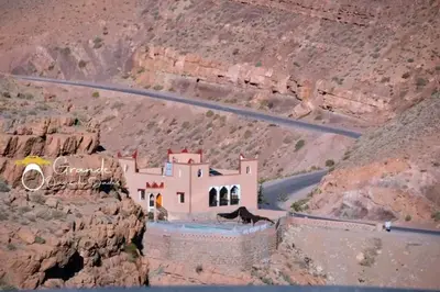 a building on the side of a mountain with a road at Kasbah lucas in Akhendachou nʼAït Ouffi