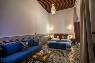a hotel room with two beds and a couch at Riad Fes Ziyat & Spa in Fès
