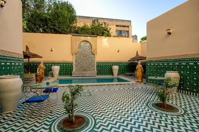 a courtyard with a pool in a building at Riad Fes Ziyat & Spa in Fès