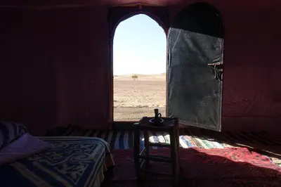 a room with a window and a bed and a chair at Sahara Berber Camp - Mhamid Discovery Camp in Mhamid El Ghizlane