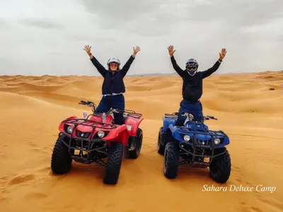 two people standing on atvs in the desert at Sahara Deluxe Camp in Merzouga