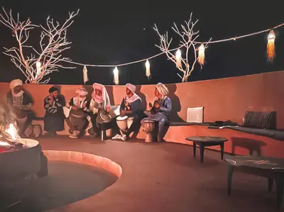 a group of women are sitting on a stage at Sahara Deluxe Camp in Merzouga
