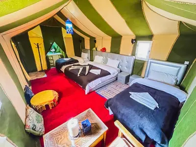 a room with two beds in a tent at Sahara Deluxe Camp in Merzouga