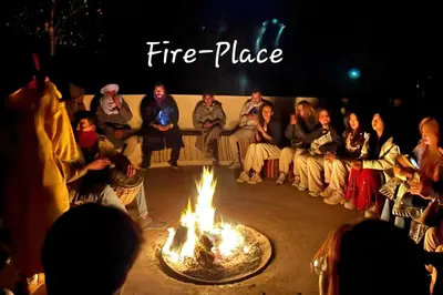 a group of people sitting around a fire place at Sahara Deluxe Camp in Merzouga