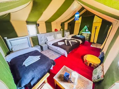 a room with two beds in a tent at Sahara Deluxe Camp in Merzouga