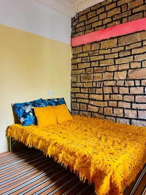 a bed in a room with a brick wall at Auberge haut atlas in Tinerhir