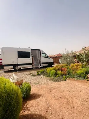 a white camper van parked in a yard at Auberge haut atlas in Tinerhir