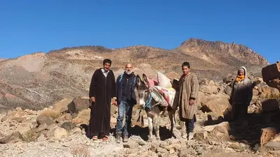 a group of people standing on rocks with a donkey at Auberge haut atlas in Tinerhir