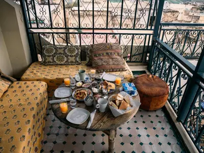 a balcony with a table with food on it at Dar Chrif Idrissi in Fès