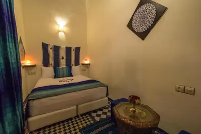 a small bedroom with a bed and a table at Dar Chrif Idrissi in Fès