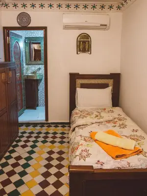 a bedroom with a bed with a sink and a mirror at Dar Chrif Idrissi in Fès