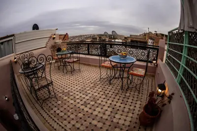 a balcony with tables and chairs on a balcony at Dar alhaja rahma in Fès
