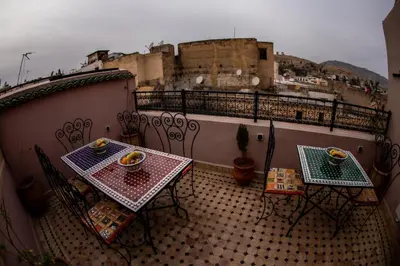 two tables and chairs on a balcony with a castle at Dar alhaja rahma in Fès