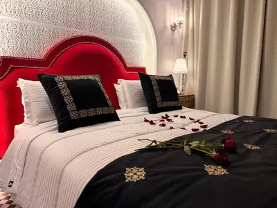 a bedroom with a red and white bed with roses on it at Riad Fes Palais Bab Sahra & Cooking Workshops in Fès