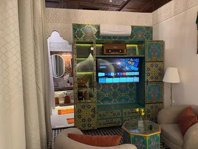 a living room with a tv and a couch at Riad Fes Palais Bab Sahra & Cooking Workshops in Fès