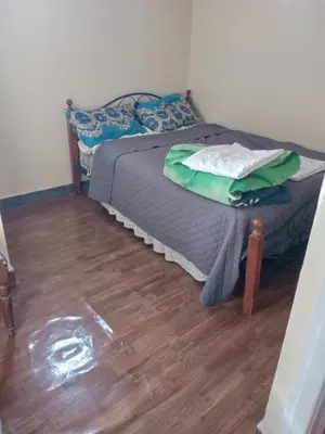 a small bed in a room with a wooden floor at appartement au centre ville in Beni Mellal