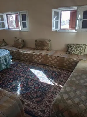 a long couch in a room with a rug at appartement au centre ville in Beni Mellal