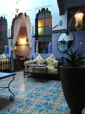 a living room with a couch and a mirror at Maison Adam in Fès