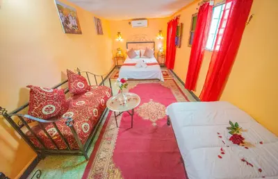 a hotel room with two beds and a couch at Maison Adam in Fès