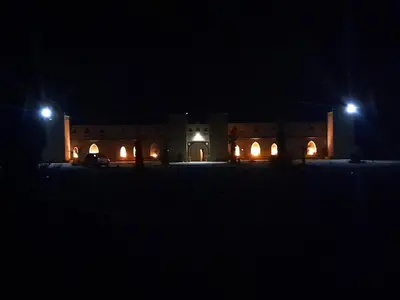 a building with two street lights at night at SANDSTAR PALACE in Merzouga