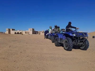 a group of people on atvs in the desert at SANDSTAR PALACE in Merzouga