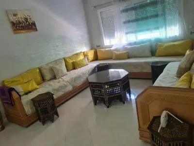 a living room with a long couch with yellow pillows at Appart. Bien équipé centre ville in Fès