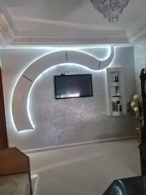 a living room with a tv on a white wall at Appart. Bien équipé centre ville in Fès