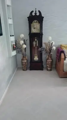 a grandfather clock sitting in a room with two vases at Appart. Bien équipé centre ville in Fès