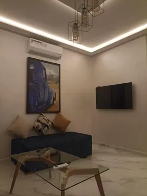 a living room with a couch and a tv at Appartement luxueux proche de tout in Fès