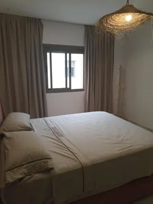 a bedroom with a large bed with a window at Appartement luxueux proche de tout in Fès