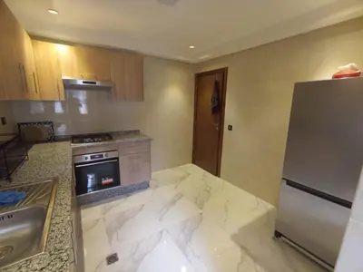 a kitchen with a refrigerator and a sink at Appartement luxueux proche de tout in Fès