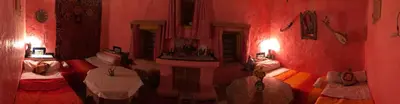 a red room with two beds and a mirror at Auberge Chez Julia in Merzouga