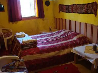 a bedroom with a bed and a sink and a window at Auberge Chez Julia in Merzouga