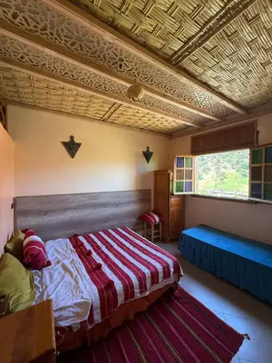 a bedroom with a large bed and a large window at Gite Rahhaoui Simo in Kasba des Aït Moussa