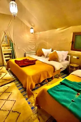 a bedroom with two beds in a tent at Sahara Magic luxury Camp in Merzouga