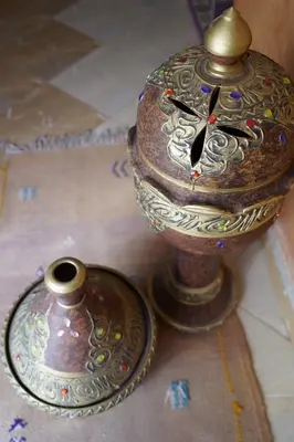 a clock and a vase sitting on a floor at CHEZ MANAR in Ouarzazate