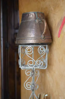 an old bell hanging on the side of a wall at CHEZ MANAR in Ouarzazate
