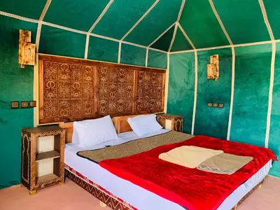 a bedroom with a large bed in a tent at Desert night Camp in Merzouga
