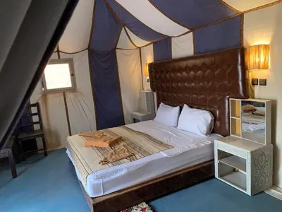 a bedroom with a large bed in a tent at Desert night Camp in Merzouga