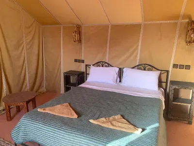 a bedroom with a bed in a tent at Desert night Camp in Merzouga