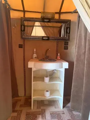 a bathroom with a sink and a mirror at Desert night Camp in Merzouga