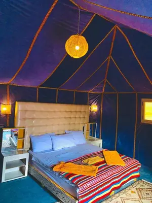 a bedroom with a bed in a tent at Desert night Camp in Merzouga