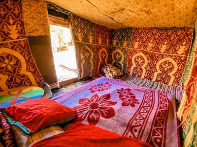 a bedroom with a bed with a blanket on it at Oasis Desert Camp Obira in Merzouga