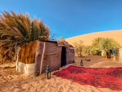 a small house in the desert with a blanket at Oasis Desert Camp Obira in Merzouga