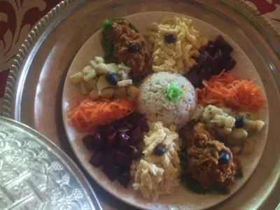 a plate of food with rice and other foods at El Menzeh Foundation in Rissani