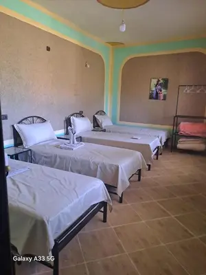 a group of four beds in a room at El Menzeh Foundation in Rissani