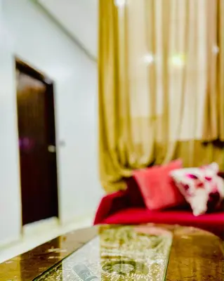 a room with a table and a red couch at COMPLEXE L'OASIS in Erfoud