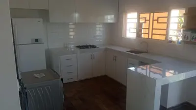 a kitchen with white cabinets and a white refrigerator at Villa 30 km a Marrakech in Marrakech