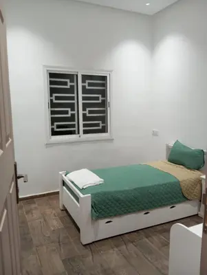 a white bedroom with a bed and a window at Villa 30 km a Marrakech in Marrakech